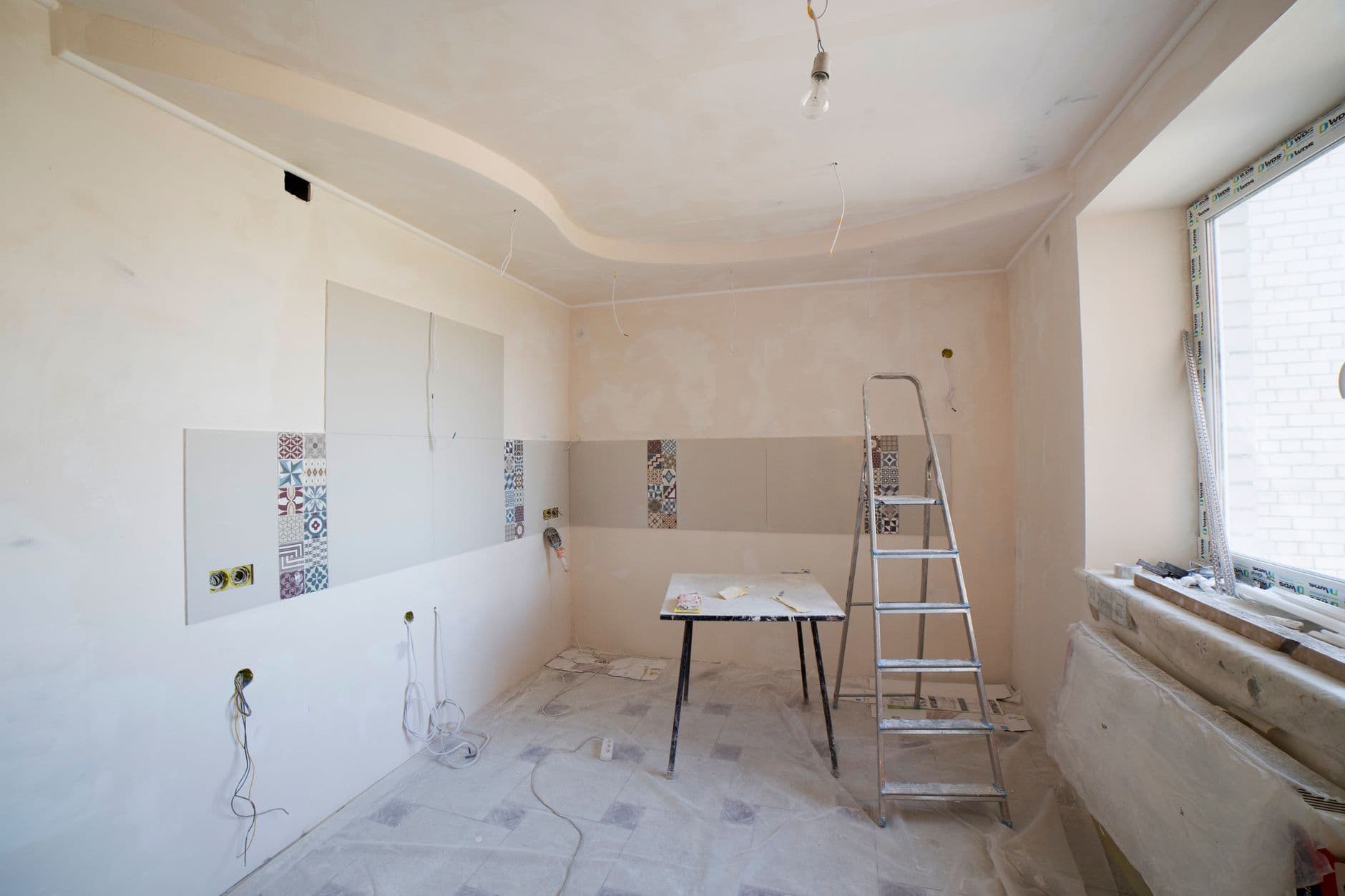 A kitchen partway through renovation, with new cabinets installed and countertops not yet in place